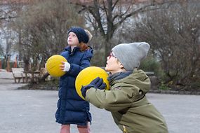 Kinder spielen Ball