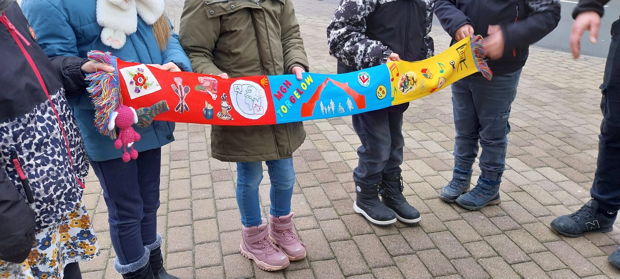 Kinder halten einen Schaul zusammen fest. 