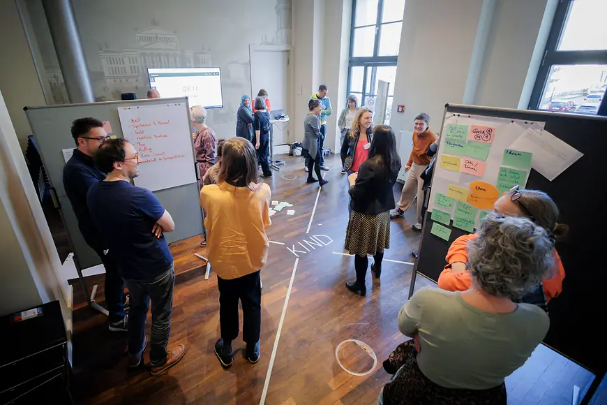 Veranstaltung mit mehreren Menschen, Whiteboard mit Informationen sind zu sehen zu sehen 