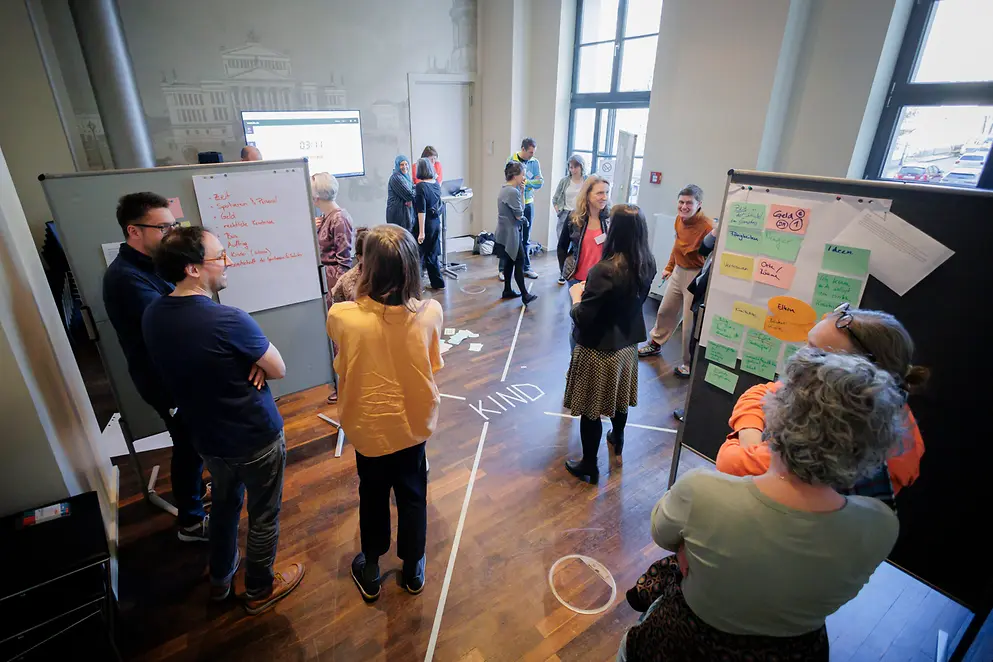 Veranstaltung mit mehreren Menschen, Whiteboard mit Informationen sind zu sehen zu sehen 